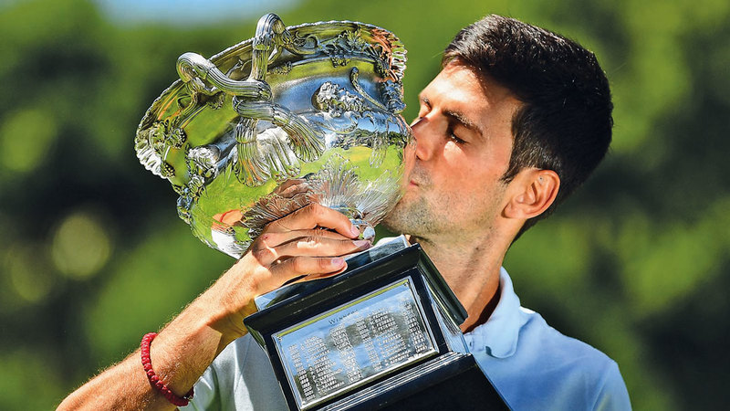 Novak Djokovic kissing his Australia Open trophy.