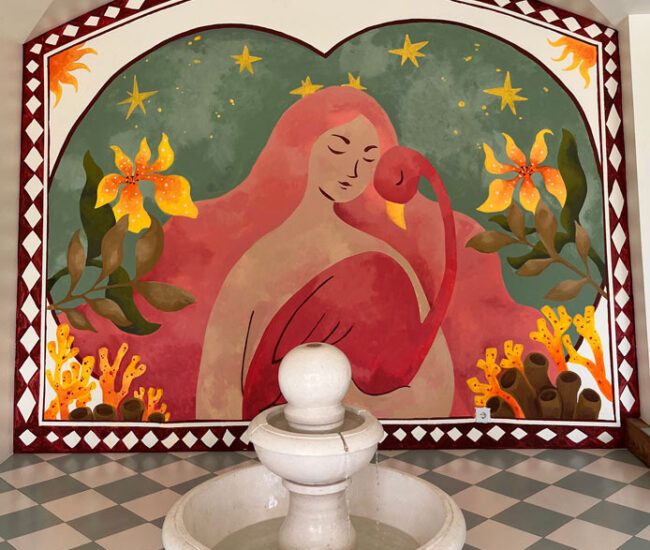 A hand-painted mural and stone fountain